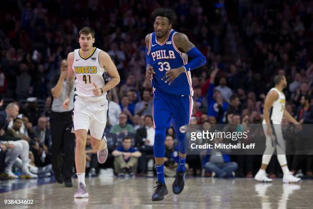 Robert Covington of the Philadelphia 76ers reacts in front of Juan Hernangomez of the Denver Nuggets after making a three point basket in the fourth...
