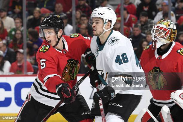 Connor Murphy of the Chicago Blackhawks and Tomas Hertl of the San Jose Sharks wait in position in front of goalie Anton Forsberg in the second...