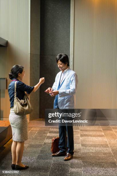 middelbare leeftijd zakenvrouw vergadering zakenman in gebouw de hal, kyoto, japan. - lypsekyo16 stockfoto's en -beelden