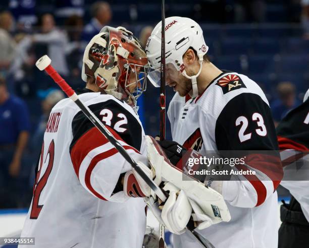 Goalie Antti Raanta and Oliver Ekman-Larsson of the Arizona Coyotes celebrate the win against the Tampa Bay Lightning at Amalie Arena on March 26,...