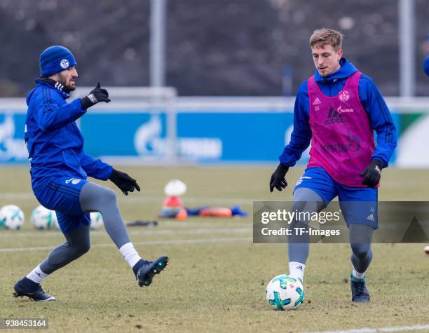 Daniel Caligiuri of Schalke and Bastian Oczipka of Schalke battle for the ball during a training session at the FC Schalke 04 Training center on...