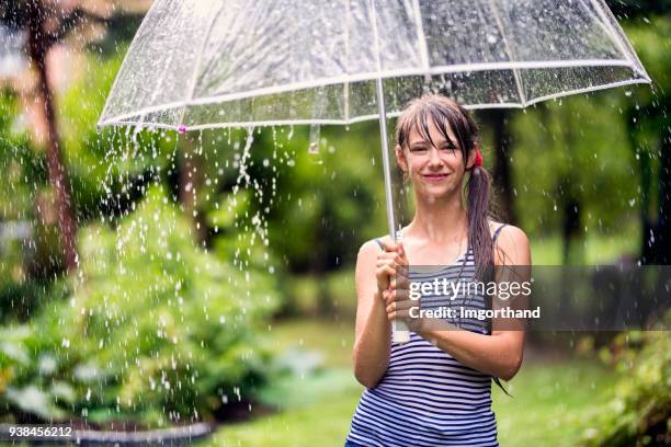 teenager-mädchen mit regenschirm, regen zu genießen - durchnässt stock-fotos und bilder