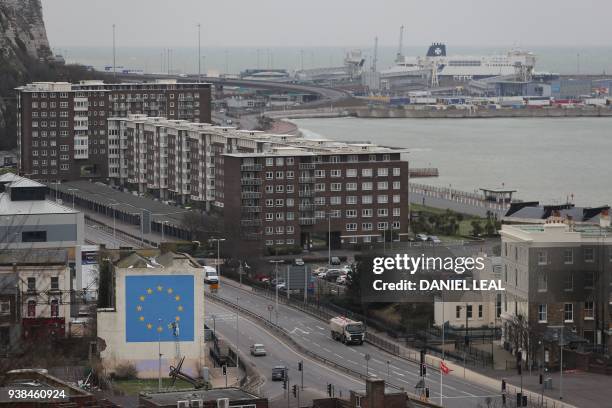 Port of Dover is seen along a mural by British artist Banksy, depicting a workman chipping away at one of the stars on a European Union themed flag,...
