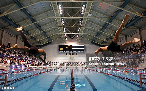 Cullen Jones and Nathan Adrian dive off the blocks at the start of the 50 yard freestyle final during day one of the AT&T Short Course Nationals at...