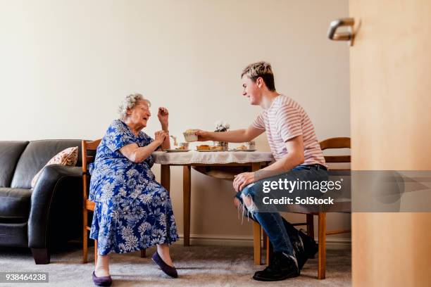 visitant sa relative âgées - happy family eating photos et images de collection