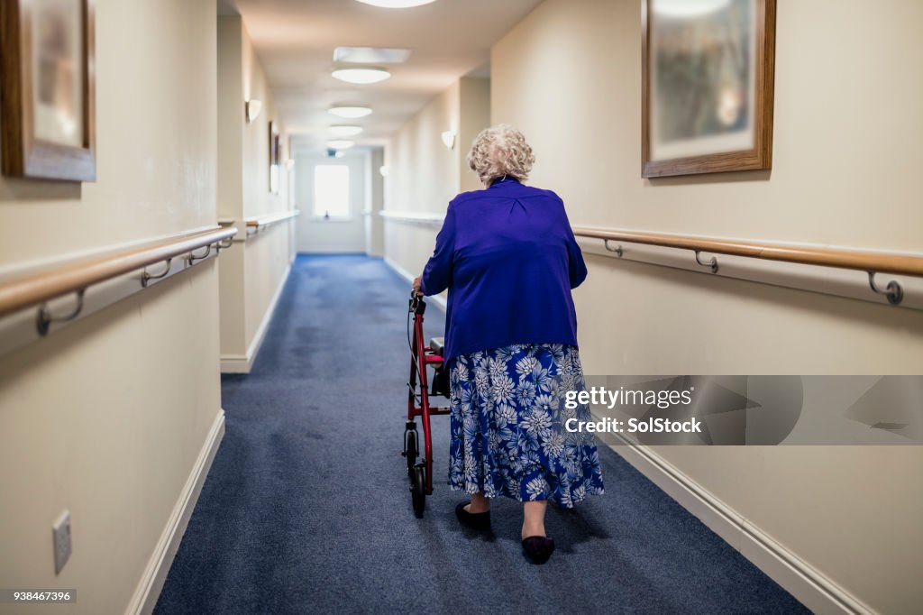 Ältere Frau mit Walker in einem Pflegeheim