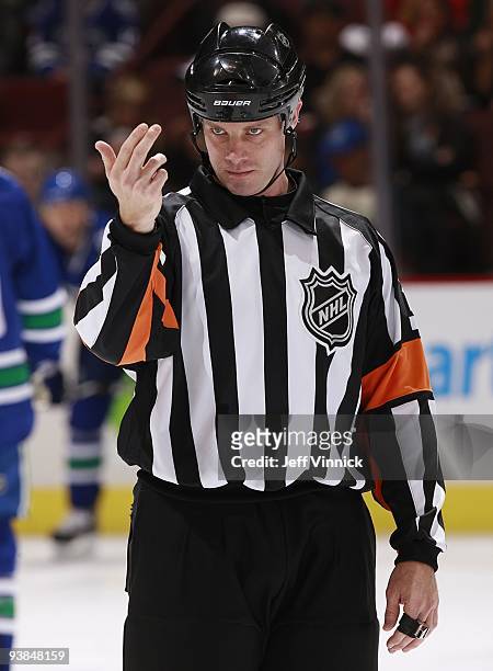 Referee Gord Dwyer makes a call during the game between the Vancouver Canucks and the Chicago Blackhawks at General Motors Place on November 22, 2009...