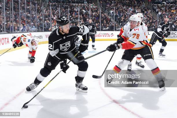 Trevor Lewis of the Los Angeles Kings handles the puck against Micheal Ferland of the Calgary Flames at STAPLES Center on March 26, 2018 in Los...