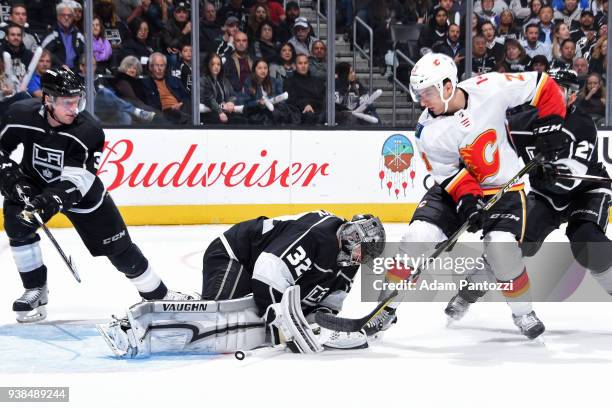 Jonathan Quick of the Los Angeles Kings makes a save against Dougie Hamilton of the Calgary Flames at STAPLES Center on March 26, 2018 in Los...