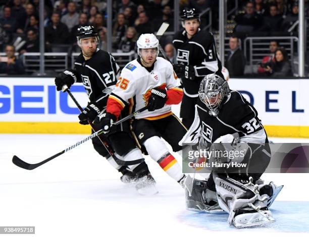 Jonathan Quick of the Los Angeles Kings makes a save as Nick Shore of the Calgary Flames looks for a rebound during the third period in a 3-0 Kings...