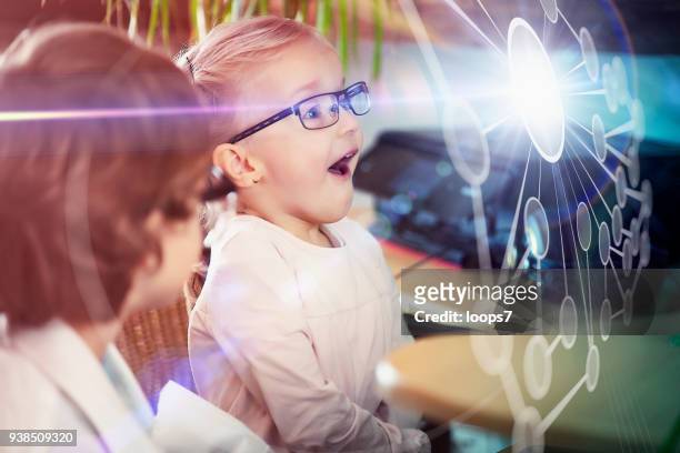 jongen en meisje kijkend naar netwerk hologram - loops7 stockfoto's en -beelden