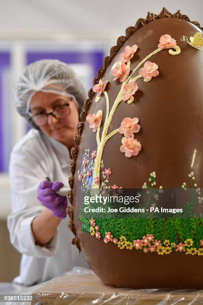 Chocolatier Dawn Jenks decorates a giant chocolate egg at Cadbury World in Birmingham.