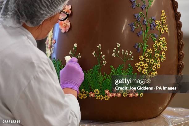 Chocolatier Dawn Jenks decorates a giant chocolate egg at Cadbury World in Birmingham.