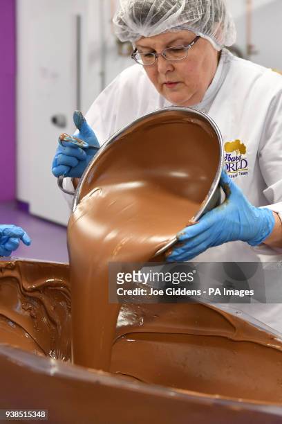Chocolatier Gail Deeley pours tempered chocolate into a mould to create a giant chocolate egg at Cadbury World in Birmingham.