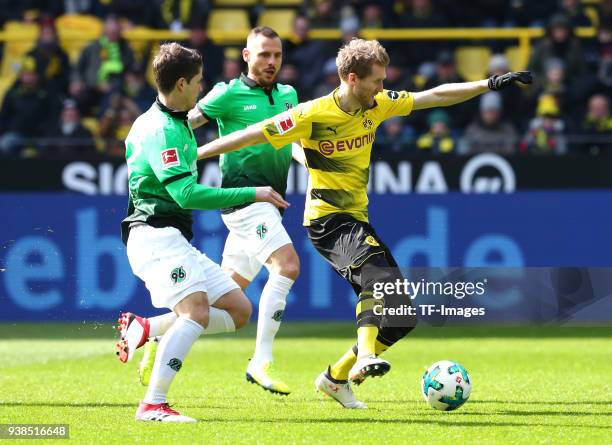 Pirmin Schwegler of Hannover, Marvin Bakalorz of Hannover and Andre Schuerrle of Dortmund battle for the ball during the Bundesliga match between...