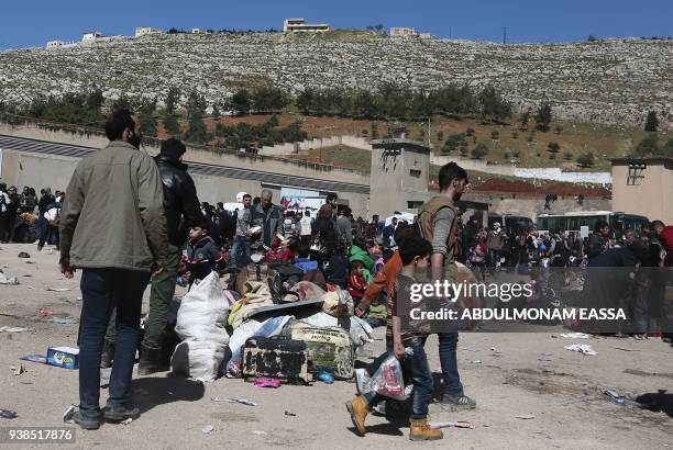 Syrian civilians and rebel fighters evacuated from Eastern Ghouta arrive in the village of Qalaat al-Madiq, some 45 kilometres northwest of the...