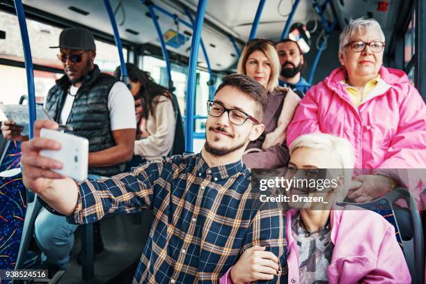 handsome man and his beautiful alternative girl taking selfie in bus - coach bus stock pictures, royalty-free photos & images