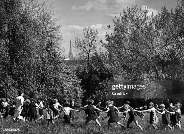 An undated picture, probably taken in the 1930s, shows little French schoolboys and schoolgirls dancing round in a circle in the garden of the...