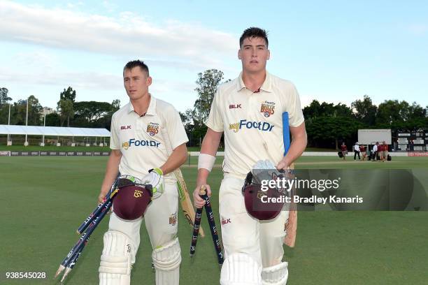 Matthew Renshaw and Marnus Labuschagne of Queensland are seen leaving the field with the stumps after claiming victory in the Sheffield Shield during...