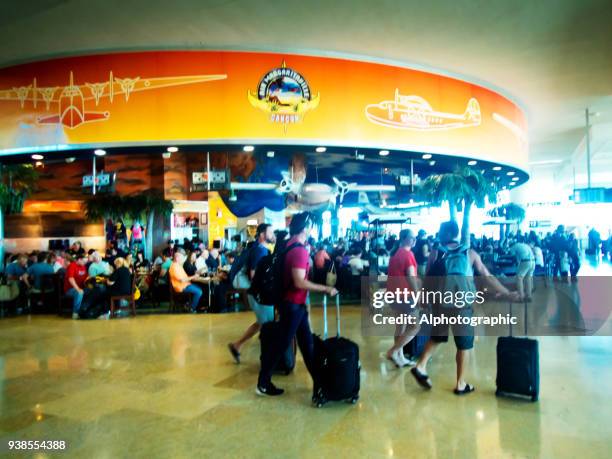 cancun airport food outlets with passengers walking past - manchester airport stock pictures, royalty-free photos & images