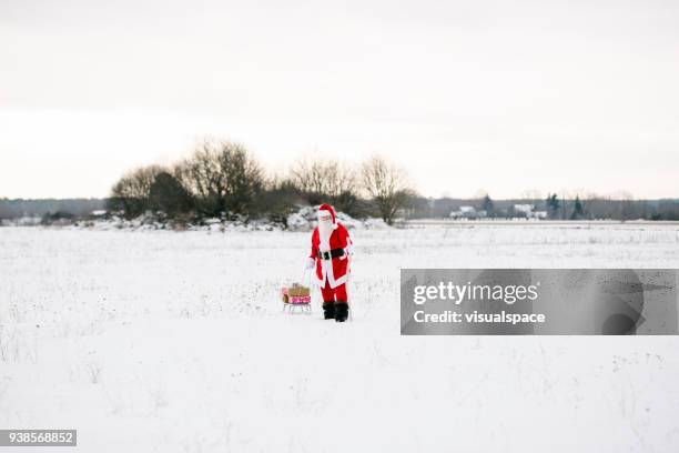 santa claus with sled and presents - sleigh stock pictures, royalty-free photos & images