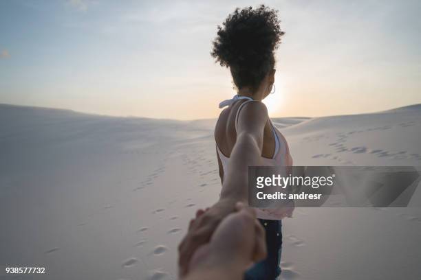 vrouw het voortouw tijdens het reizen in de woestijn - couple dunes stockfoto's en -beelden