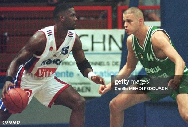 Le Français Ronnie Smith , est aux prises, le 12 juin 1999 à Caen, avec le Slovène Radoslav Nesterovic, lors de la rencontre France/Slovénie...