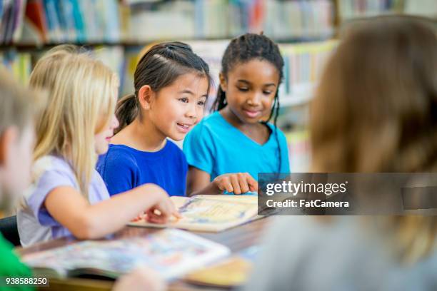 girls reading in a group - kids all ages stock pictures, royalty-free photos & images