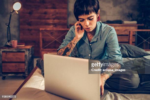 eenzame vrouw in bed met behulp van internet op zoek naar partner - lesbian dating stockfoto's en -beelden