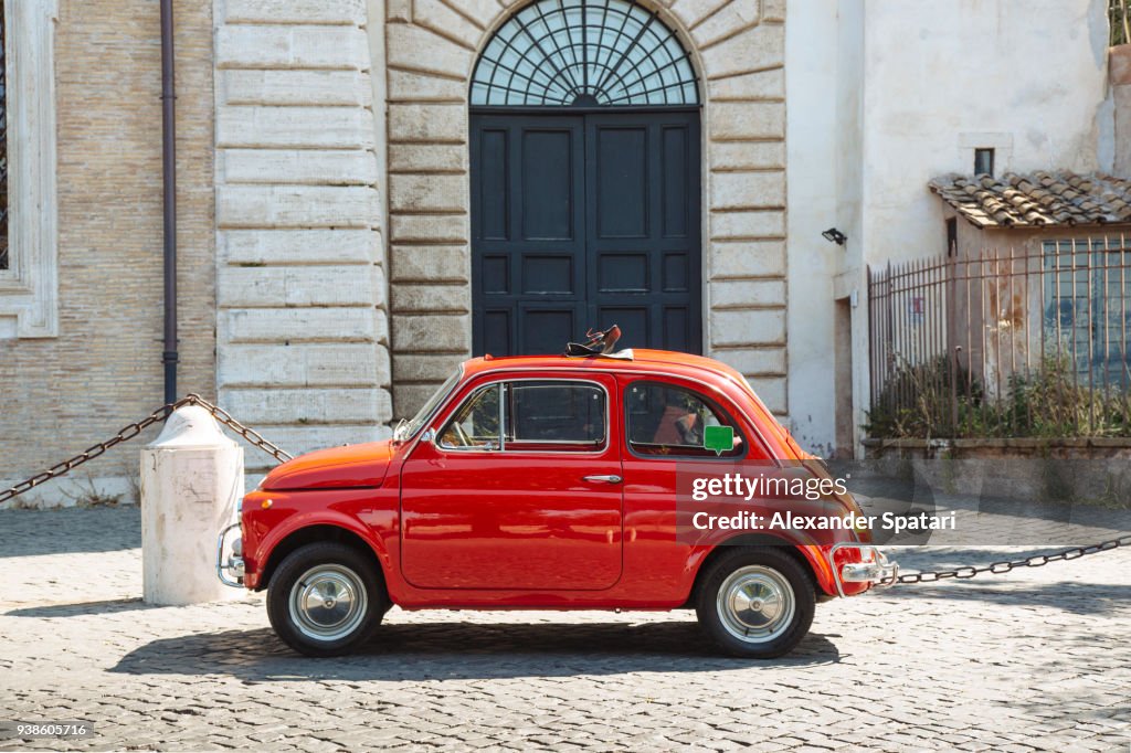 Old small red vintage car on the streets of Rome, Italy