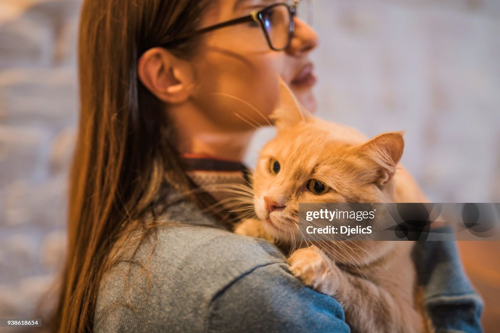 Young woman holding her beautiful Maine Coon cat.