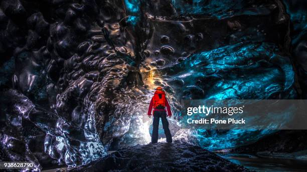 man exploring an amazing glacial cave in iceland - pioneer stock pictures, royalty-free photos & images