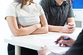 Unhappy couple in meeting with therapist, psychologist, divorce lawyer or legal consultant. Upset woman and man having fight in therapy session or marriage counselling.
