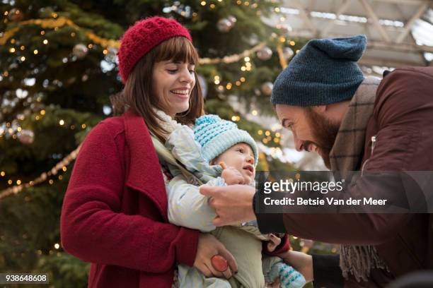 father greets child and mother in arrival hall near christmas tree. - betsie van der meer stock pictures, royalty-free photos & images
