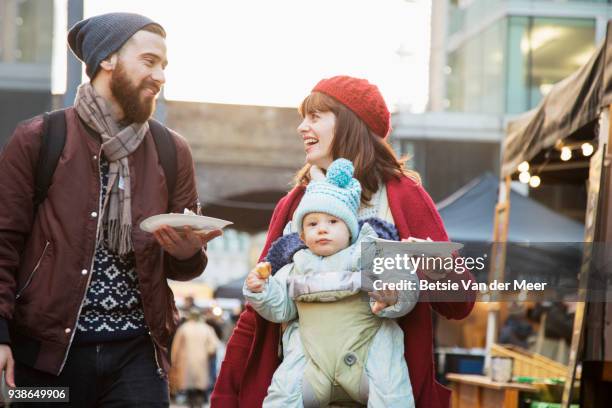 parents are walking with child and take away food in street market. - father son business europe stock-fotos und bilder