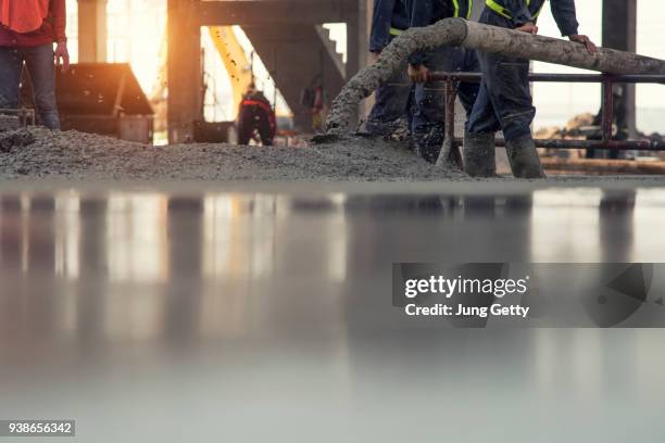 construction worker concrete pouring during commercial concreting floors of building in construction site and civil engineer - zement stock pictures, royalty-free photos & images