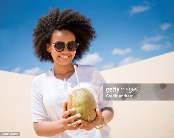 happy brazilian woman drinking a cocktail at the desert - coconut beach woman stock pictures, royalty-free photos & images