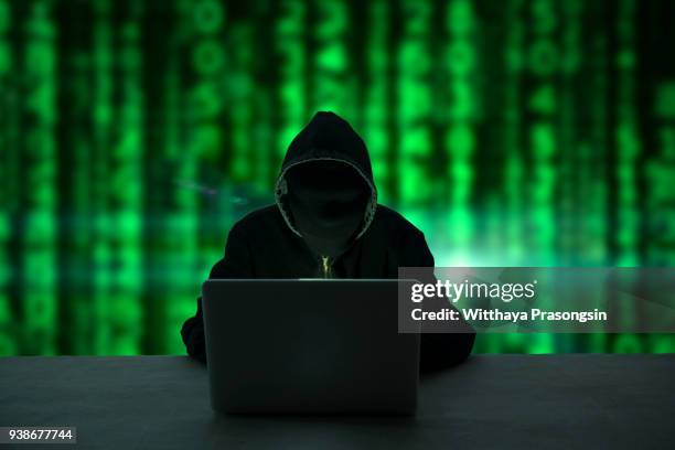 hacker in front of his computer. dark face - anonymous mask photos et images de collection
