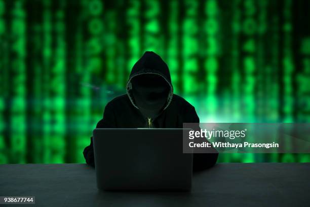 hacker in front of his computer. dark face - fraud protection 個照片及圖片檔