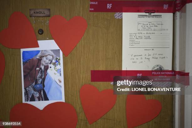 Picture taken on March 27, 2018 shows a picture of Mireille Knoll, heart-shaped documents and seals of the police posted on the door of her apartment...