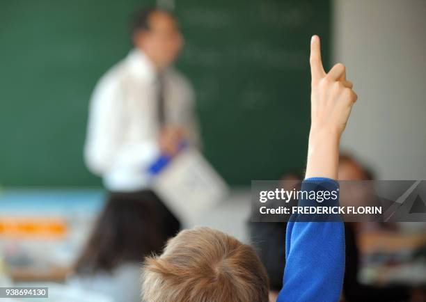 Un jeune écolier lève le doigt pour prendre la parole dans sa salle de classe, le 02 septembre 2010 à Strasbourg le jour de la rentrée scolaire....