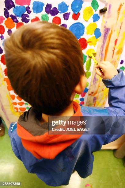 Handicapés : la scolarité presque ordinaire de Théo, enfant autiste" - Théo, atteint de troubles autistiques, fait des exercices de peinture le 06...