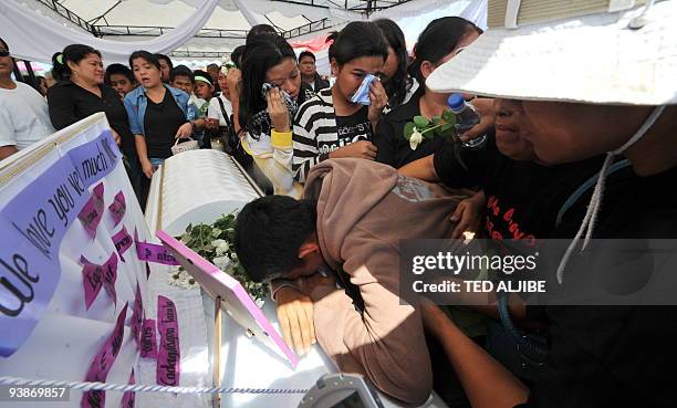 Relatives of one of the slain journalists mourn over the coffin during the funeral in General Santos City, south Cotabato on December 4, 2009. Eight...