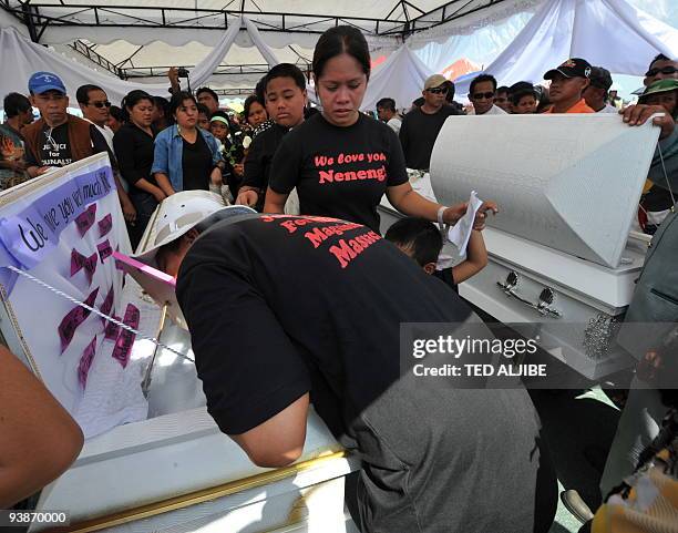 Relative of one of the slain journalists kisses a portrait during the funeral in General Santos City, south Cotabato on December 4, 2009. Eight of...