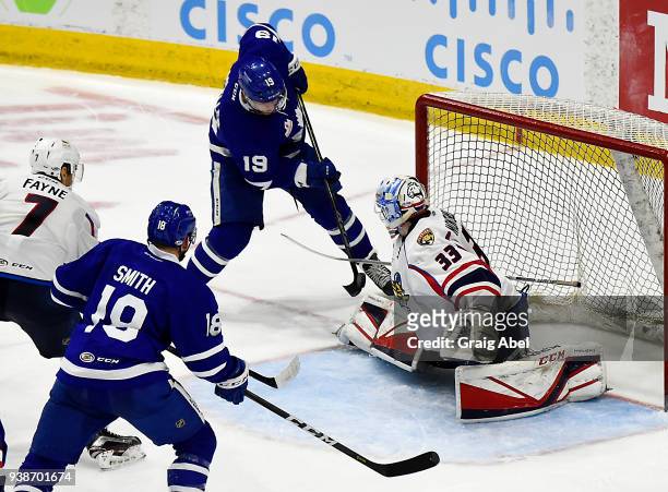 Chris Mueller of the Toronto Marlies tries to put the puck past goalie Samuel Montembeault of the Springfield Thunderbirds while Ben Smith of the...