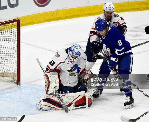 Trevor Moore of the Toronto Marlies battles for loose puck against goalie Samuel Montembeault and Tim Erixon of the Springfield Thunderbirds during...