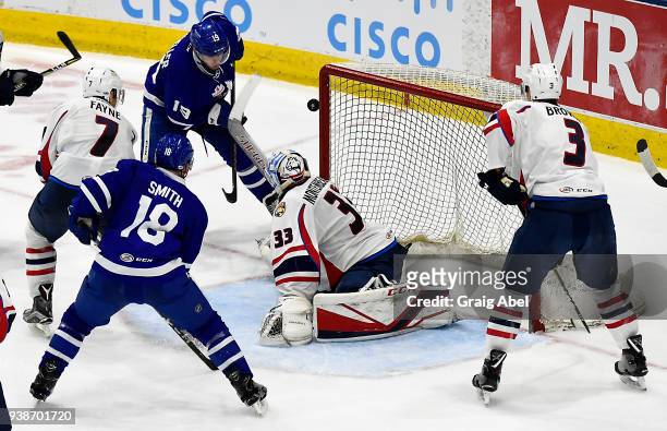 Chris Mueller of the Toronto Marlies tries to puck the puck past goalie Samuel Montembeault of the Springfield Thunderbirds while Ben Smith of the...