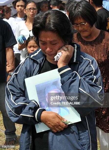 Relative of one of the slain journalists holds a photo during the funeral mass in General Santos City, south Cotabato on December 4, 2009. Eight of...