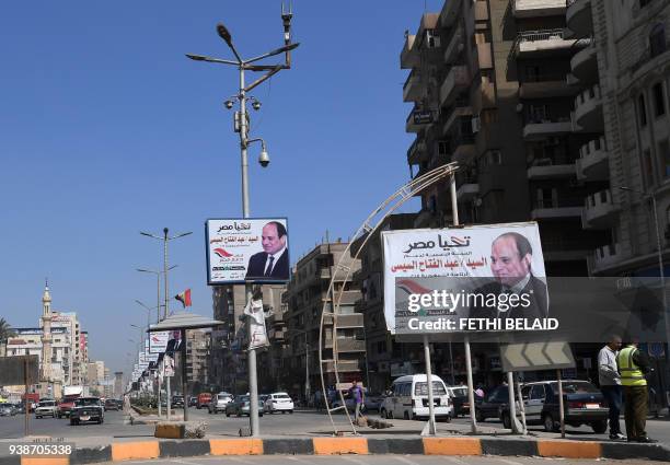 Picture taken on March 27, 2018 shows electoral posters commissioned by the official campaign for incumbent Egyptian President Abdel Fattah al-Sisi...