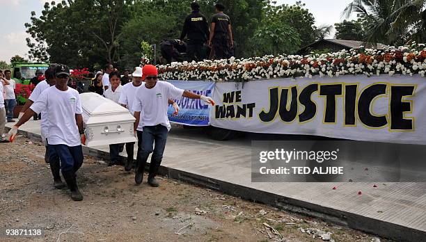 Workers carry the coffin of one of the slain journalists during the funeral in General Santos City, south Cotabato on December 4, 2009. Eight of the...